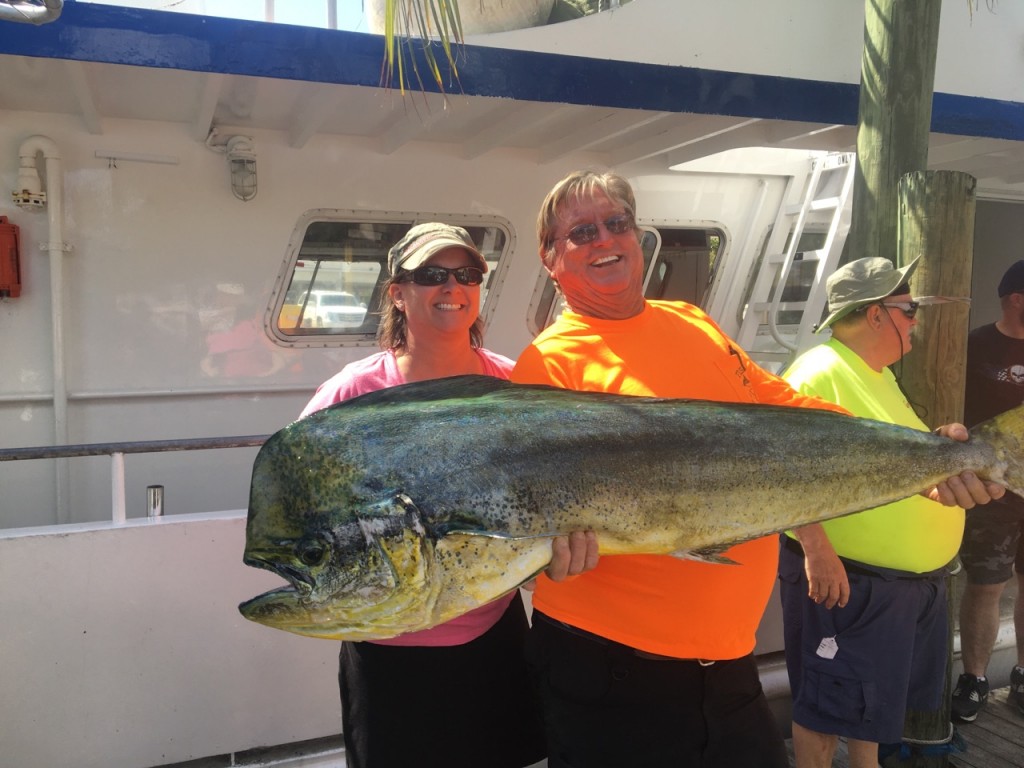 Huge bull dolphin fish being held by Capt. Paul and lady angler