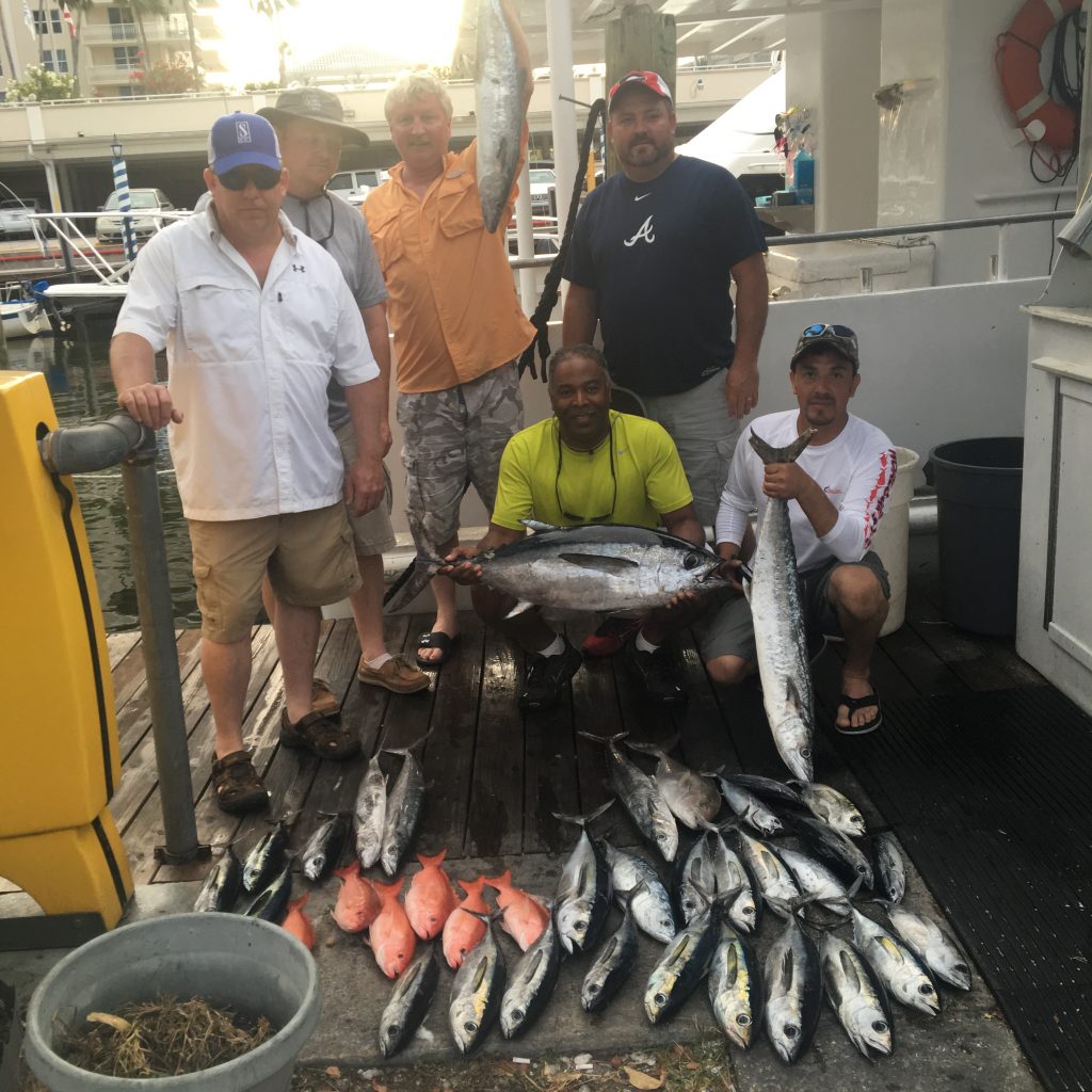 The guys posing with their catch of tunas, kingfish and snapper on our sport fishing charter.