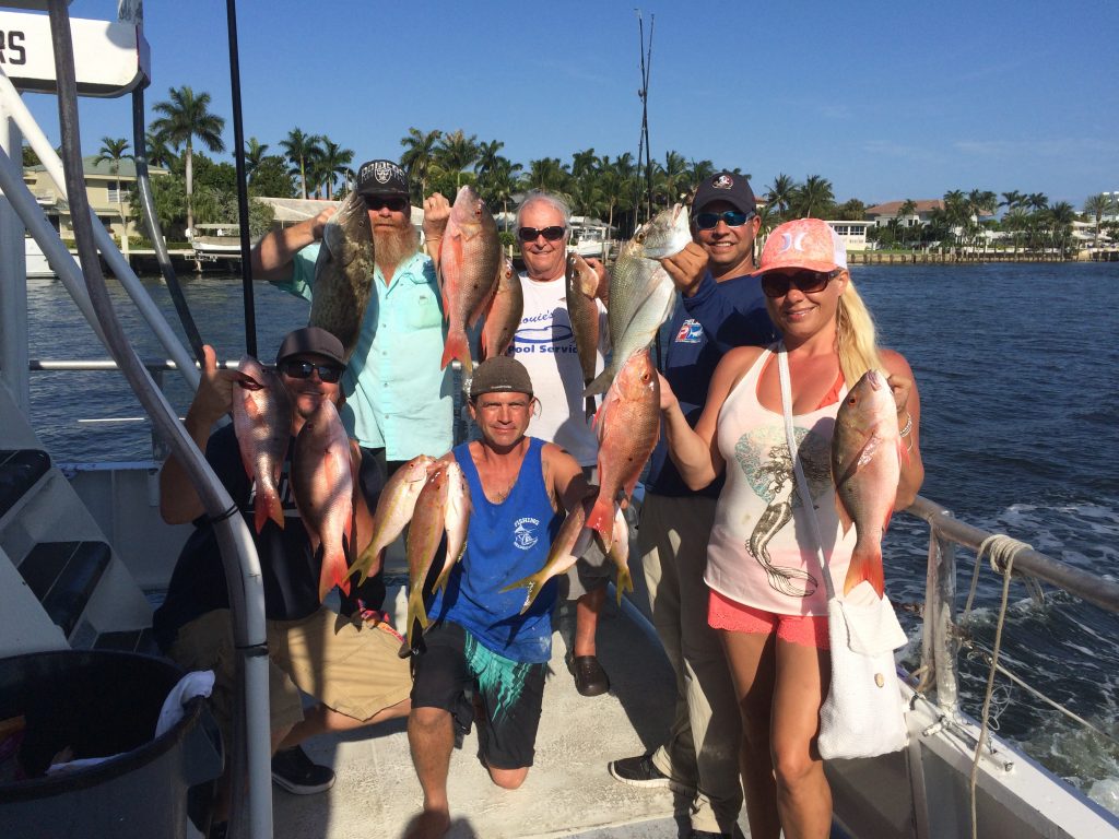 Group gathered in the back of the Catch My Drift holding a great catch of snappers.