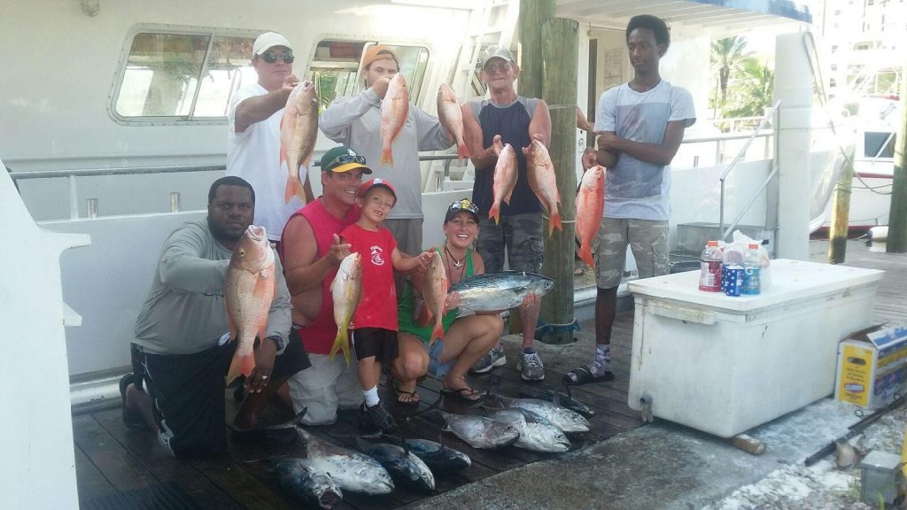 Happy anglers holding up their drift fishing catch at the dock.