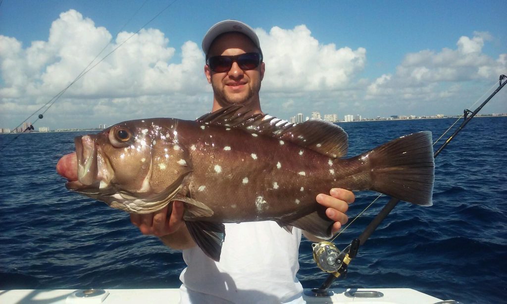 Happy angler holding a nice snowy grouper