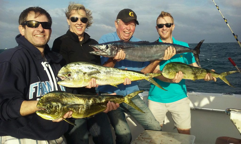 A group holding wahoos and dolphins on our charter.