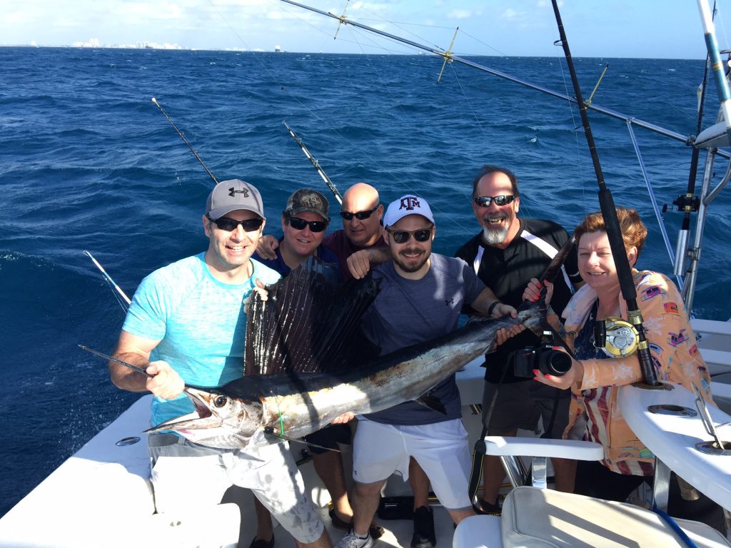 Sailfish being held by a fishing family.