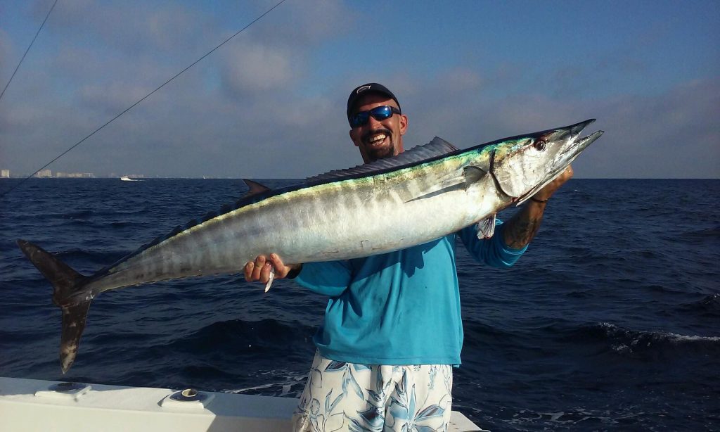 Mick holding a wahoo all lit up and iridescent.