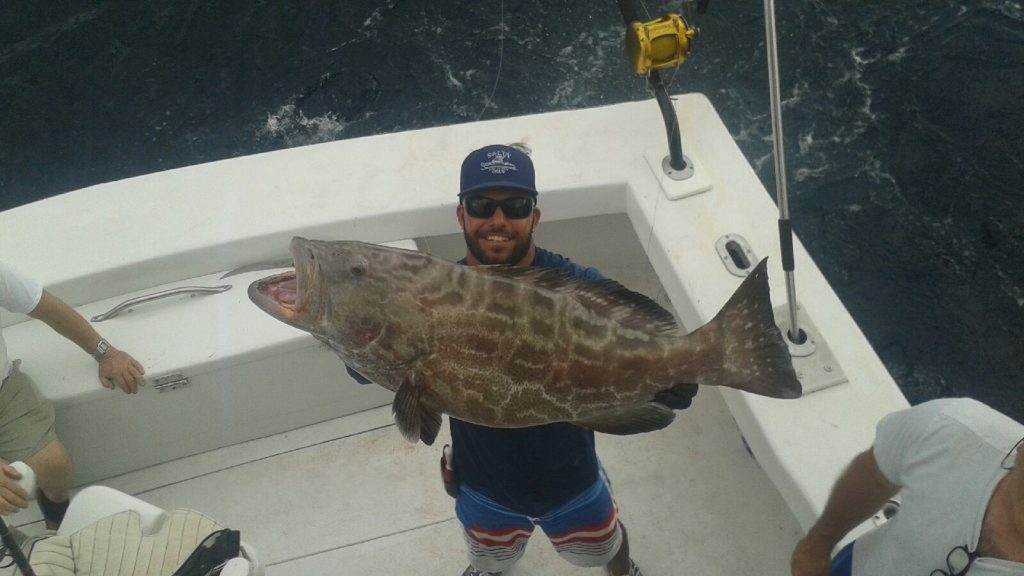 Bobby holding a really big grouper just caught.