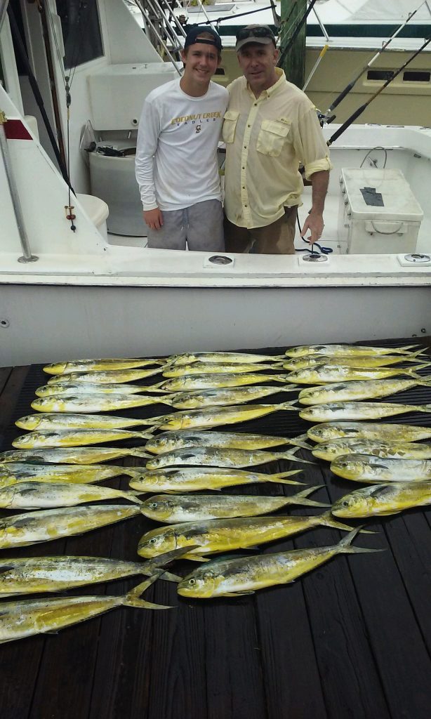 Father and son with a boatload of mahi-mahi caught on our sportfishing charter.