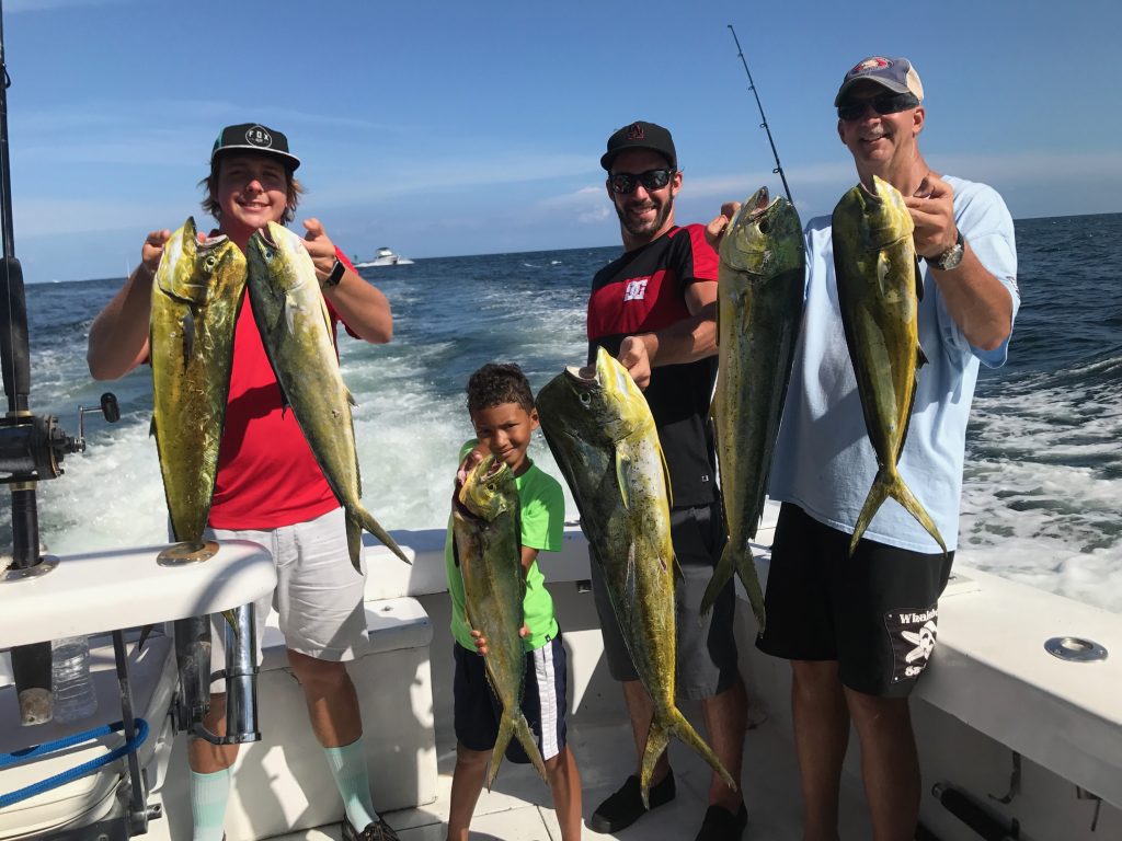 The boys out on the boat holding a nice bunch of good sized mahi-mahi.