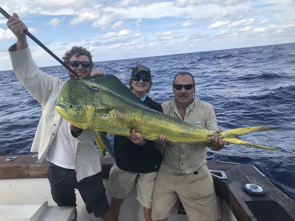 Dan, Pat and Alex holding an approx 50 pound bull dolphin just caught on a deep sea fishing trip.