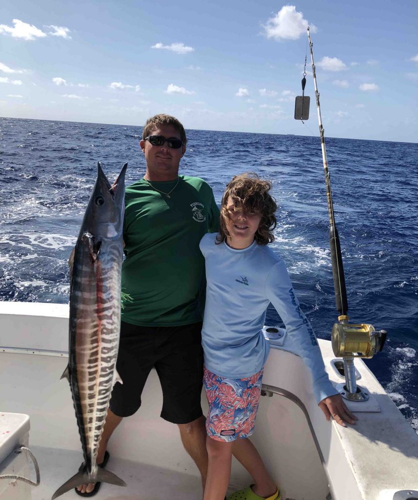 Capt Rod and the angler posing with a big wahoo they just caught trolling the reef.