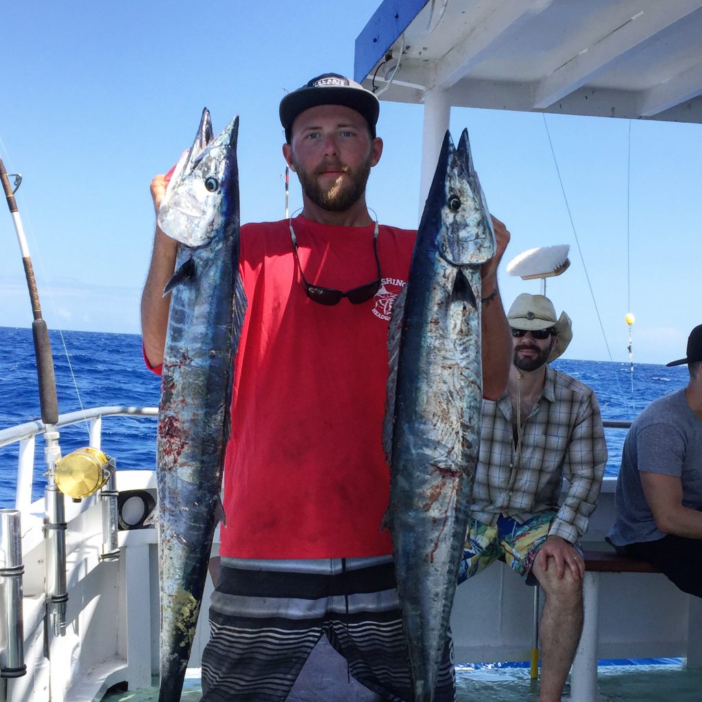 Josh holding a pair of wahoo caught on a bachelor party fishing trip out of Fort Lauderdale