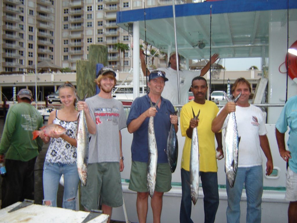 A group holding their fish up after the trip.