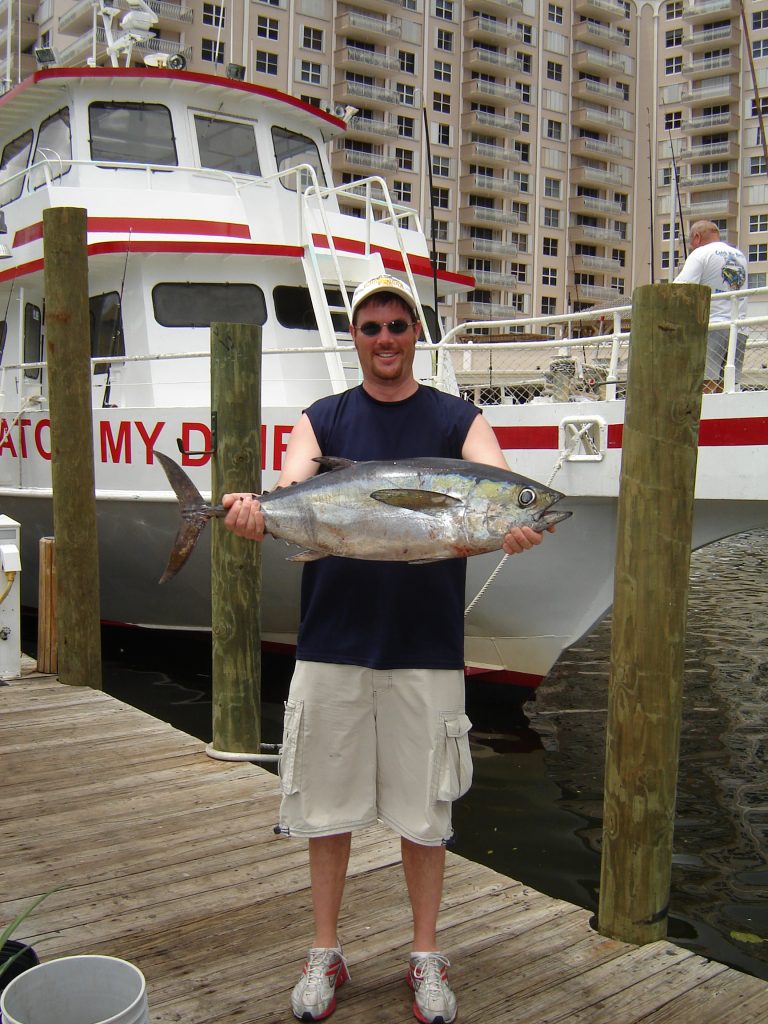 Proud angler posing with a blackfin tuna he caught on a head boat fishing trip in Ft Lauderdale