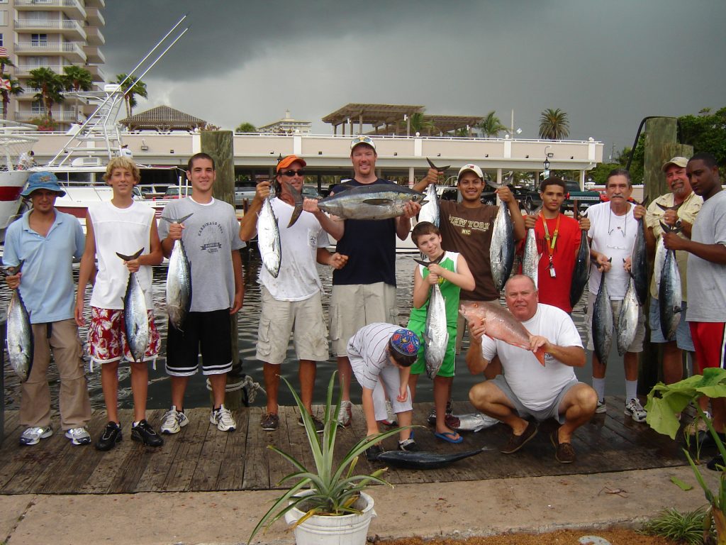 Group just out fishing holding up their fish