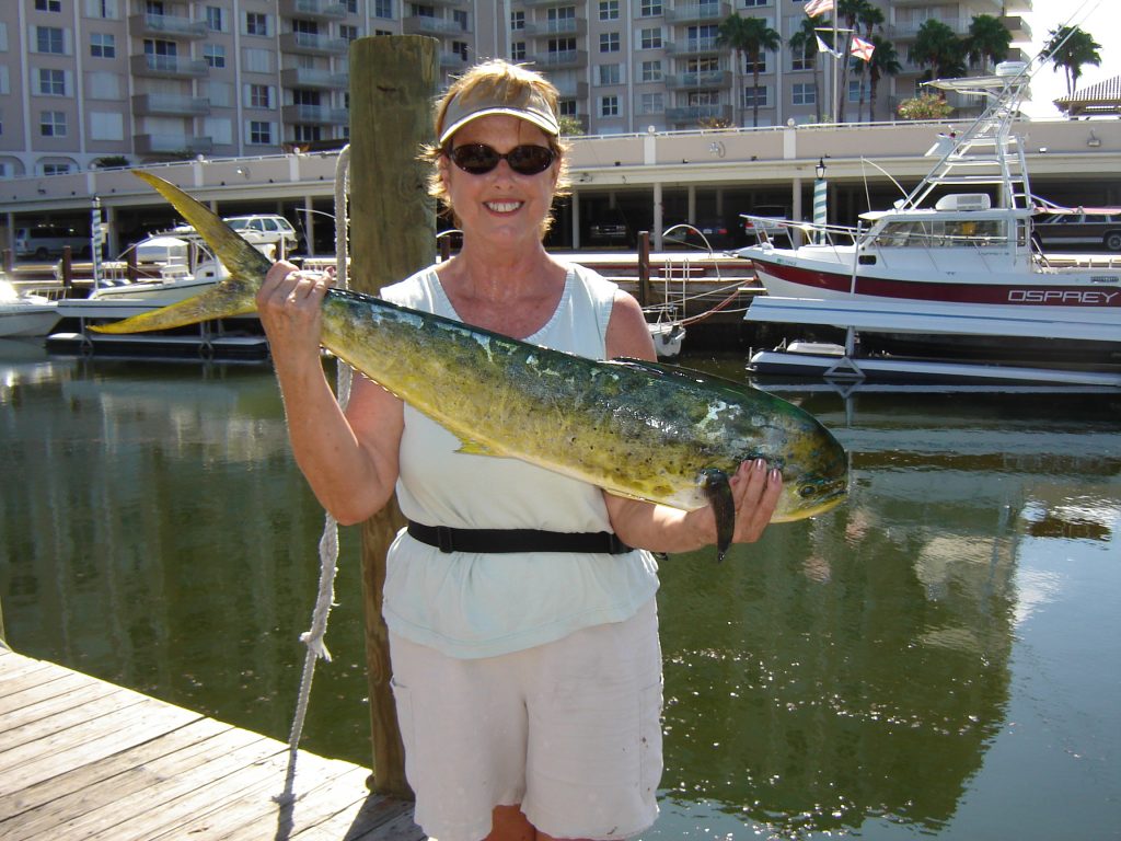 Happy lady holding her dolphin that she caught on our drift fishing trip