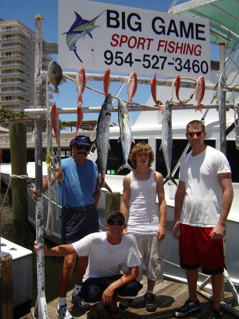 Folks posing with their fish after their deep sea charter fishing trip