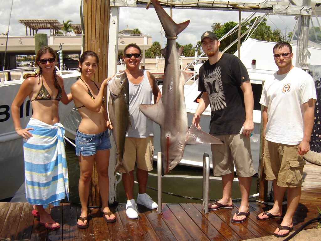 Folks posing with a great catch on our shark fishing charter in Fort Lauderdale