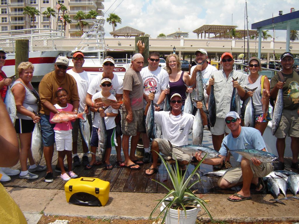 Fun group charter on our head boat posing with their catch