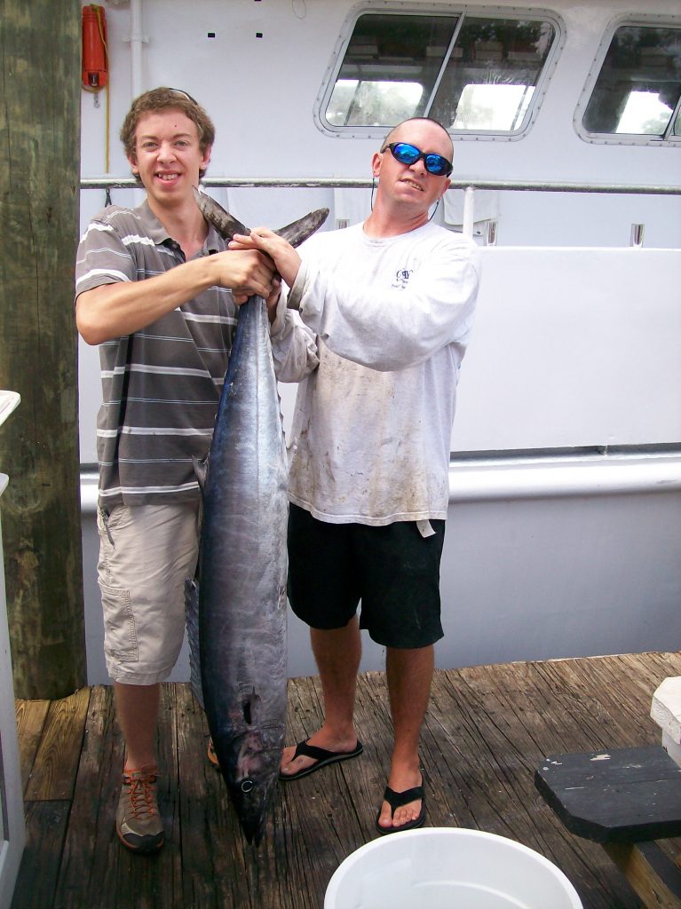 Kevin and a happy angler holding up a wahoo caught on our drift boat, at the dock.