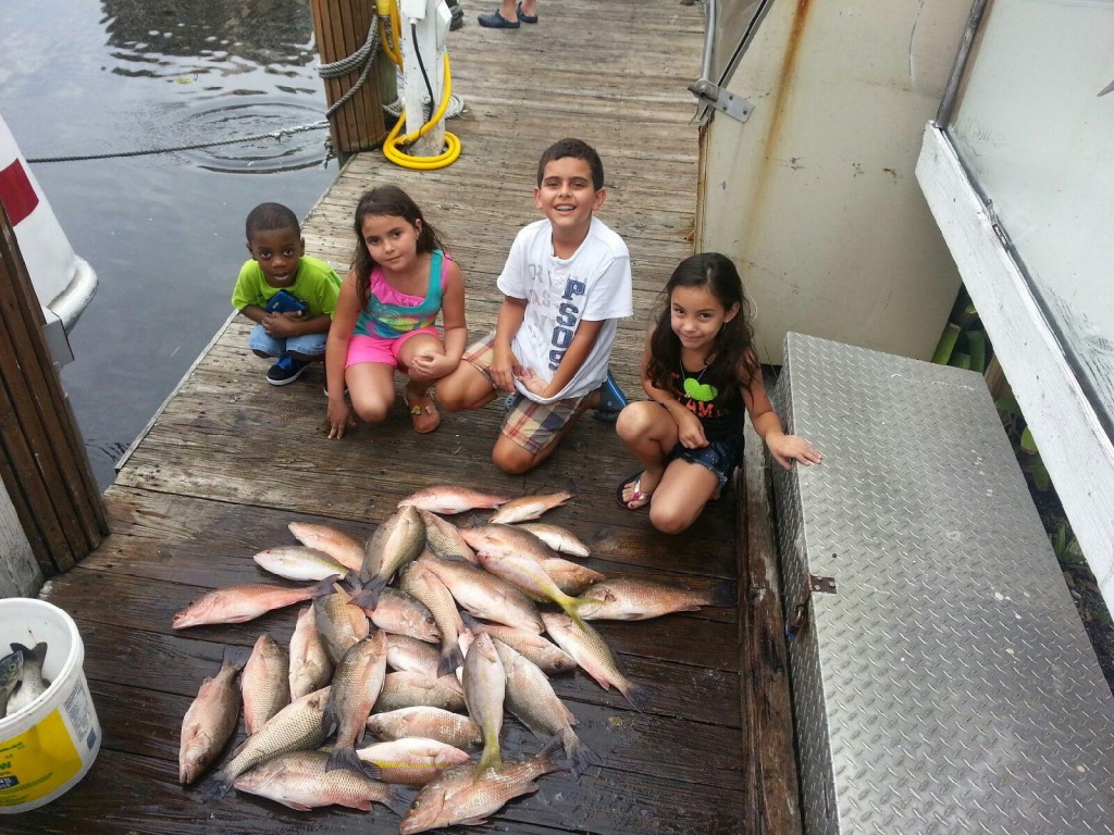Kids at the dock with their snapper catch