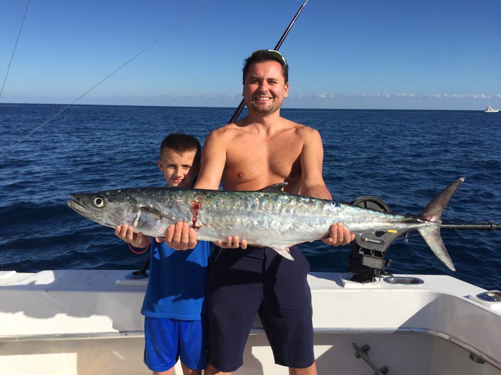 Nice kingfish being held by father on a fishing trip.