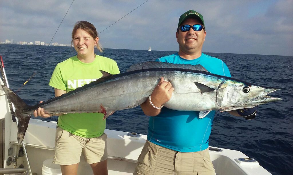 Father/Daughter holding a huge wahoo they just caught.