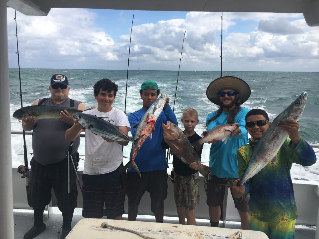 Anglers holding their catch of mahi, kingfish, tuna and grouper on the back of the Catch My Drift