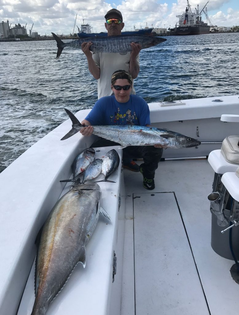 Father and son holding some nice fish caught on a deep sea fishing charter.