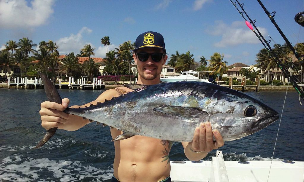 Guy holding a blackfin tuna in the Fort Lauderdale Intracoastal Waterway.