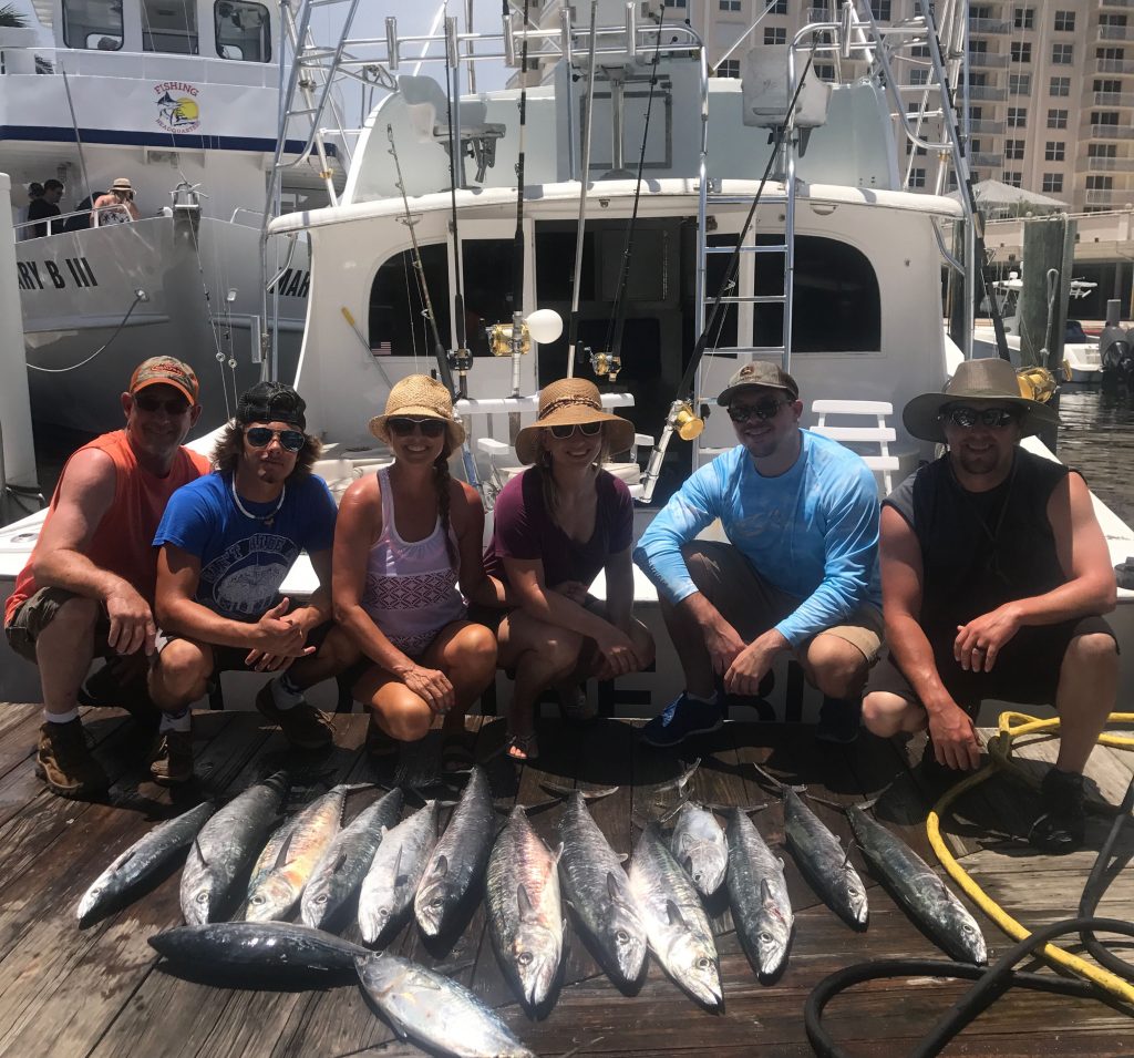 Family just back from a fishing trip with lots of kingfish.