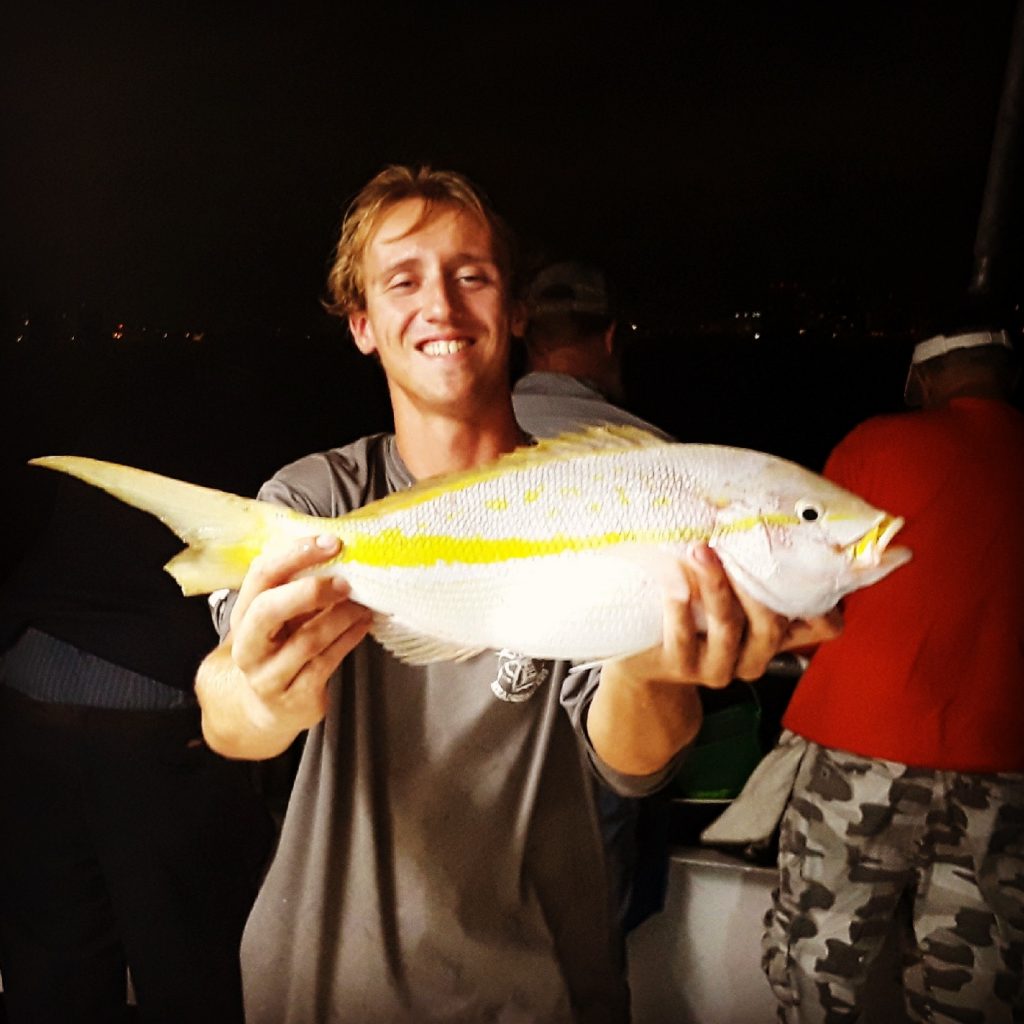 Matt, very happy, holding a big yellowtail snapper he just caught at night.