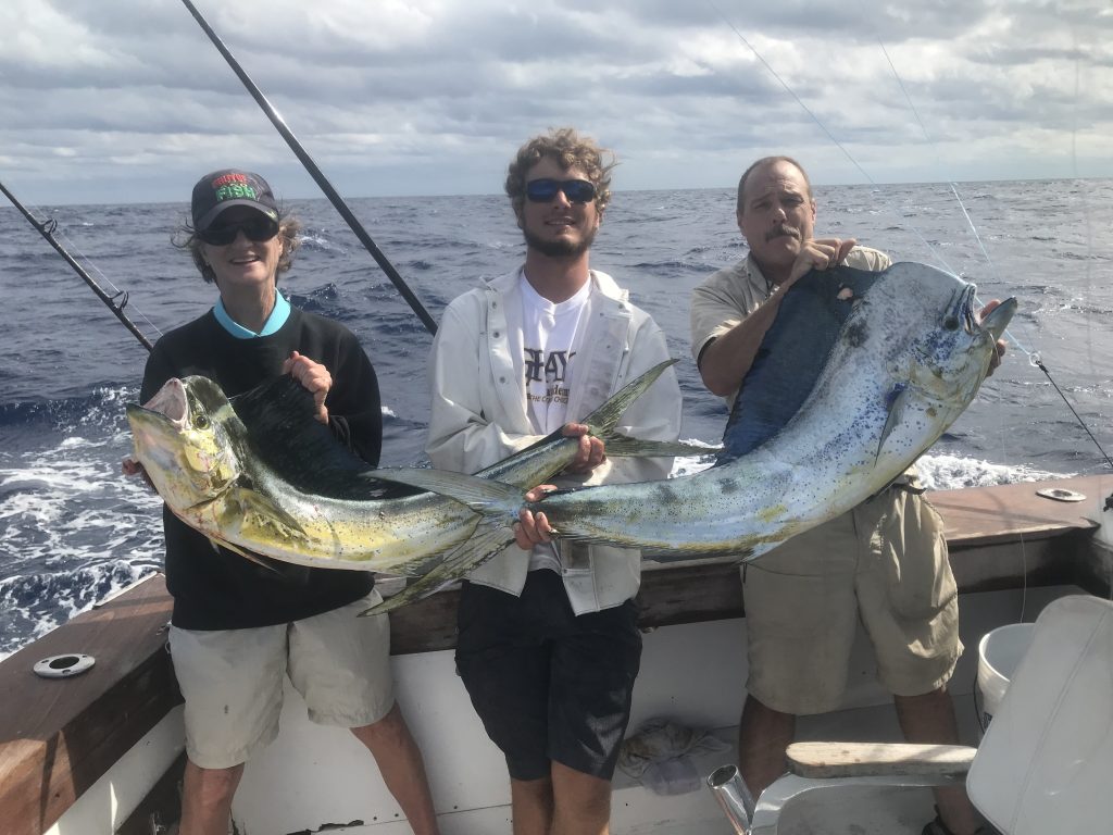 Dan, Pat and Alex holding a pair of big dolphin fish just caught, one of the dolphin over 45 pounds.