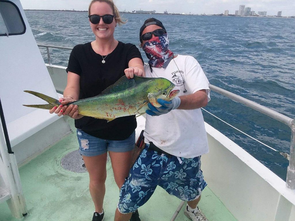 happy lady angler posing with her mahi she just caught offshore of Fort Lauderdale.