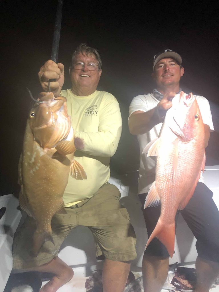 Father and son holding a big grouper and nice snapper that were just caught fishing in Fort Lauderdale.