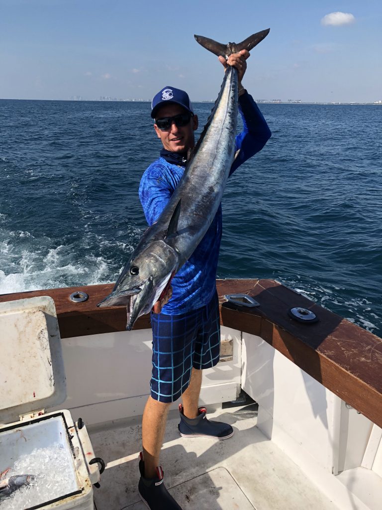 Andrew holding a 30 pound wahoo just caught trolling at sea.