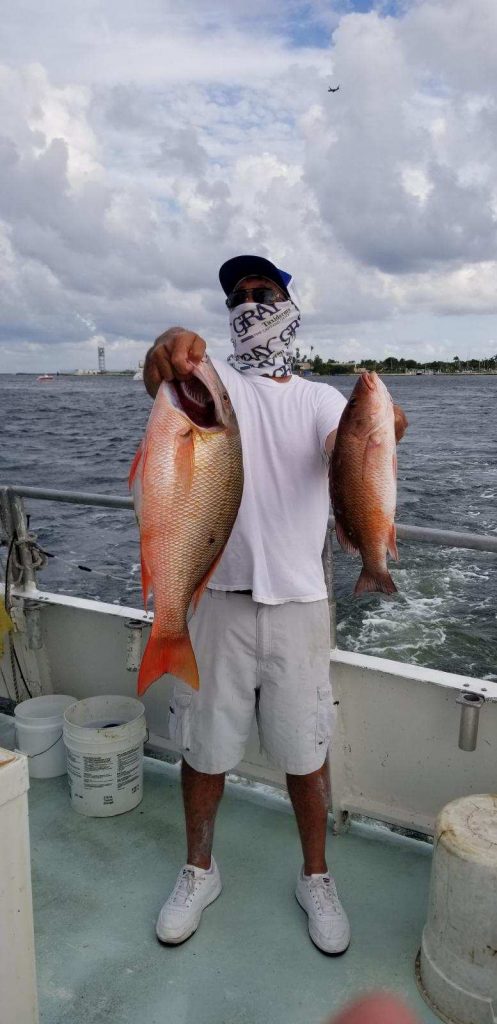 John holding a pair of big snapper on his trip aboard the Catch My Drift