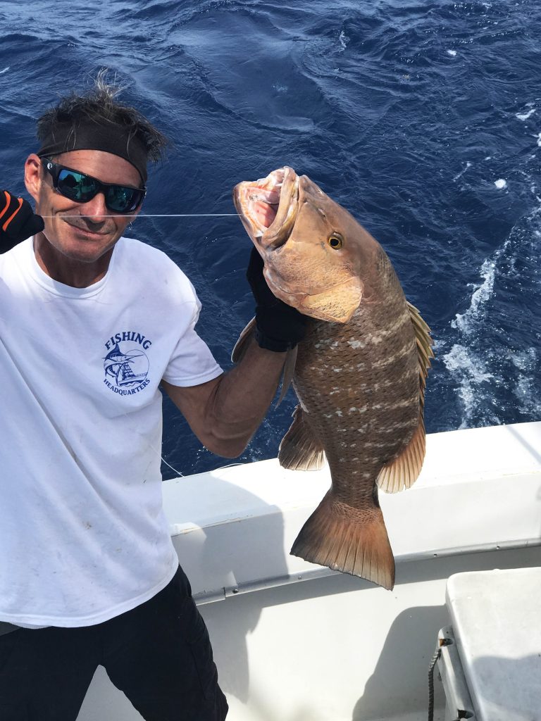 Cubera snapper being held with the rig still in his mouth.