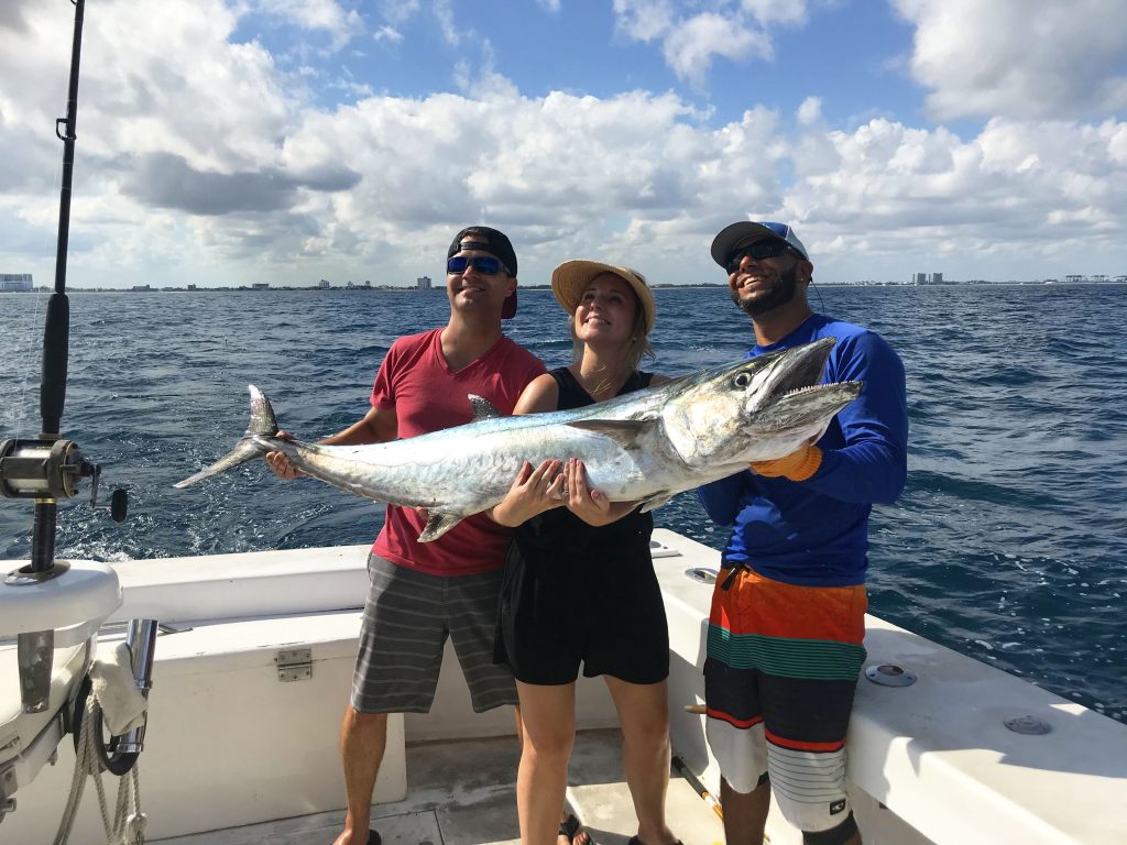 Bobby and couple on vacation posing with their huge kingfish, just caught offshore Ft Lauderdale beach