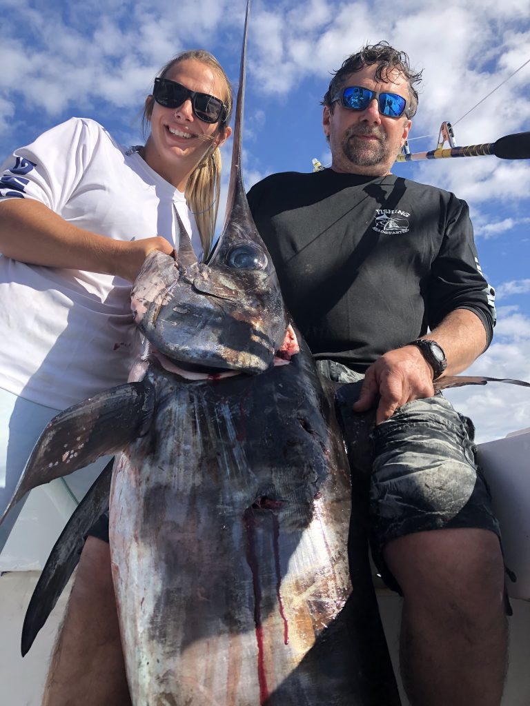 Kaylee and her dad holding a huge swordfish just caught off Fort Lauderdale