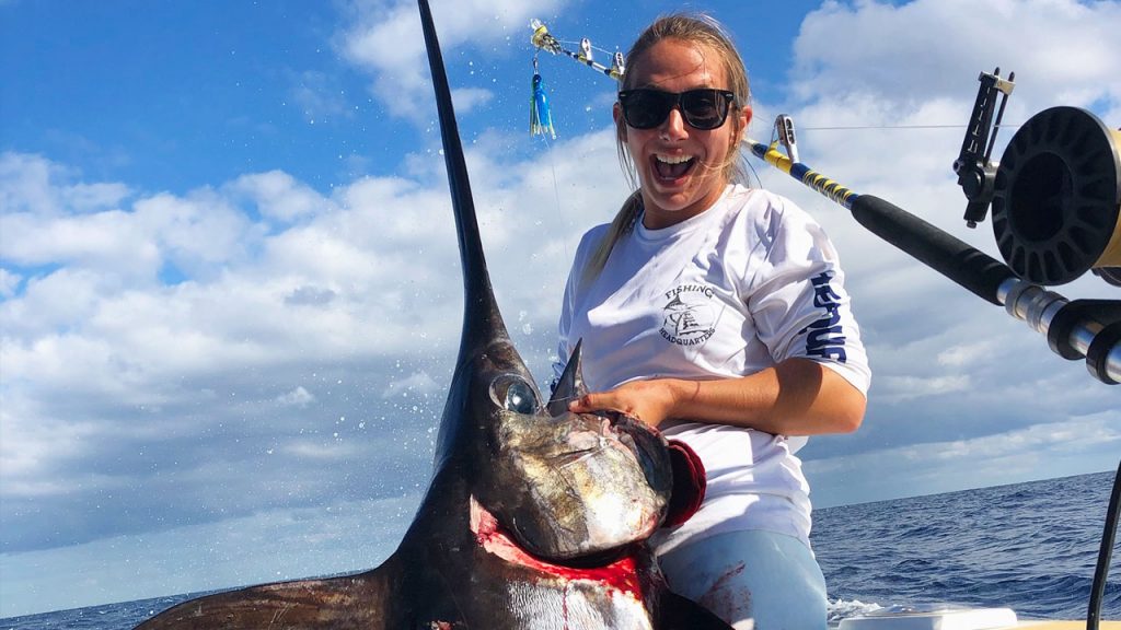 Kaylee holding a swordfish that she just caught on our daytime swordfishing charter