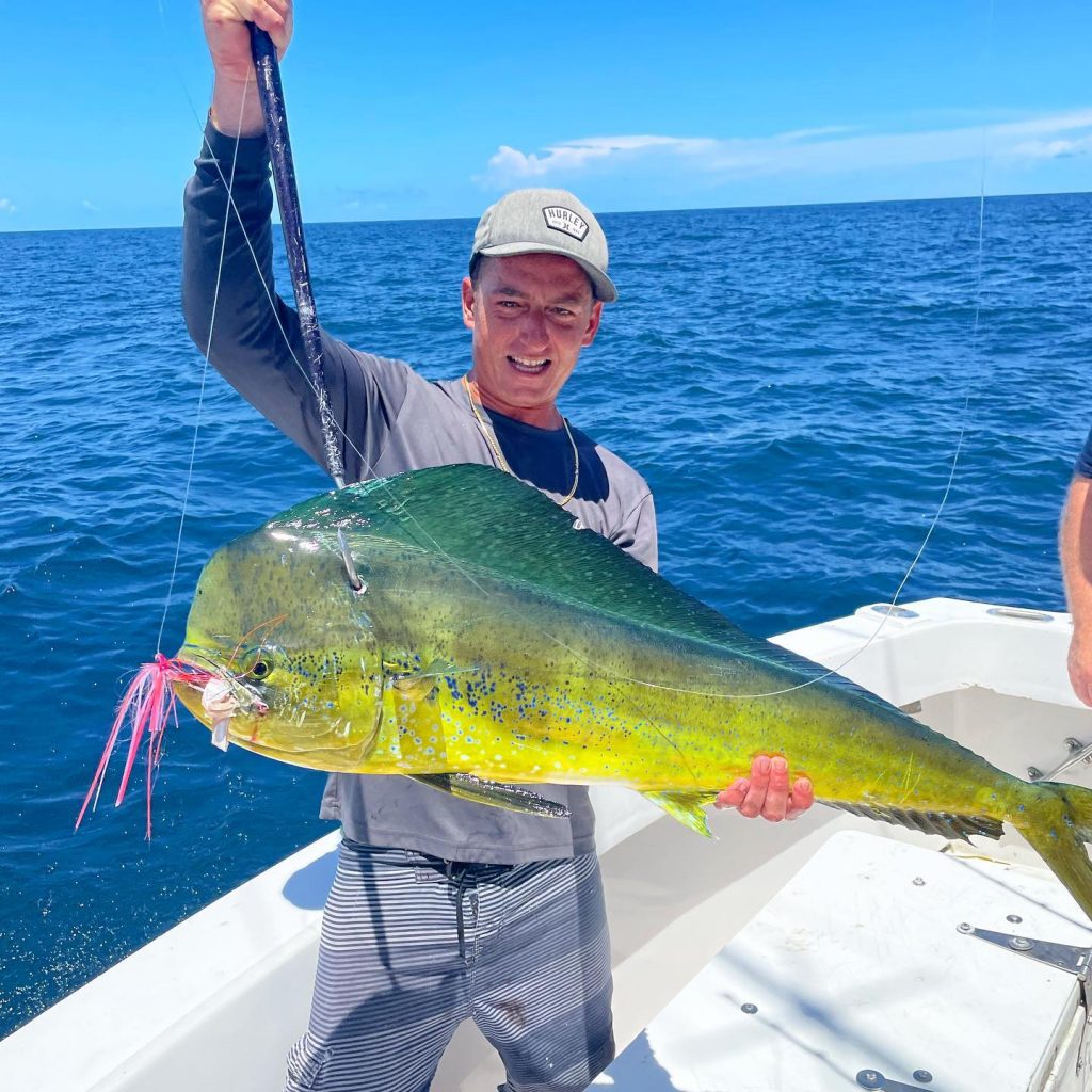 Andrew holding a big bull dolphin with the bait still in it's mouth 